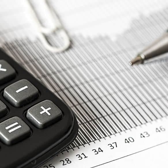 Calculatrice, stylo et graphique financier sur un bureau