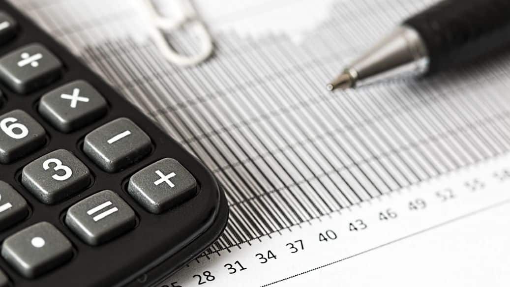Calculatrice, stylo et graphique financier sur un bureau d’expert-comptable